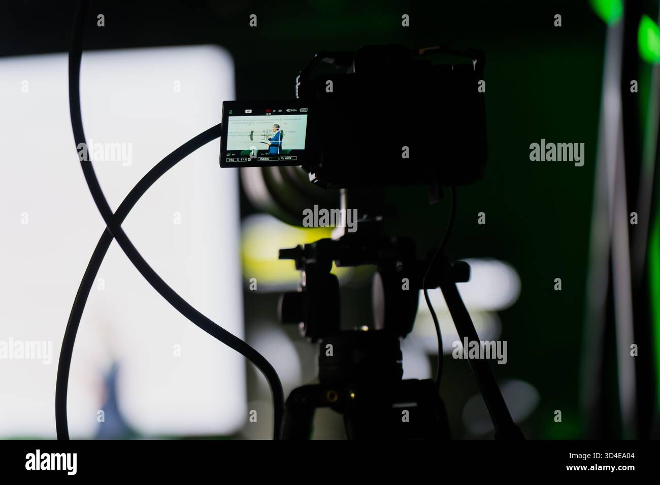 Vista dietro le quinte del display della fotocamera che mostra il presentatore a fuoco durante la registrazione di eventi teatrali, rappresentazione artistica di riprese professionali, tecnologia Foto Stock