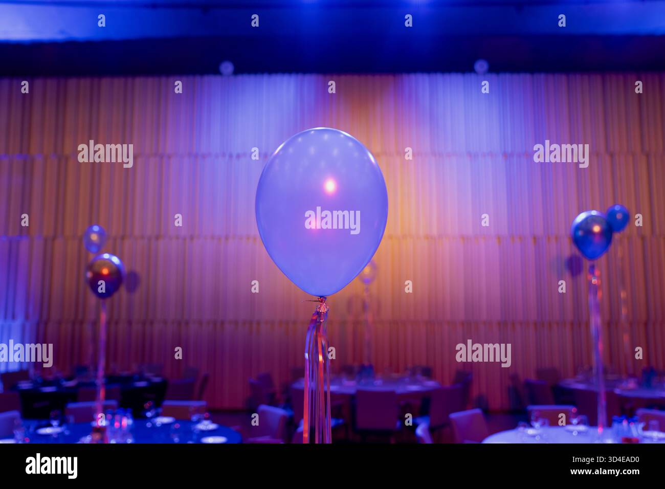 Il pallone all'elio è un elemento decorativo per eventi all'interno di banchetti, sotto una luce colorata, simboleggia l'industria dell'ospitalità, l'organizzazione di eventi e l'arredamento moderno Foto Stock