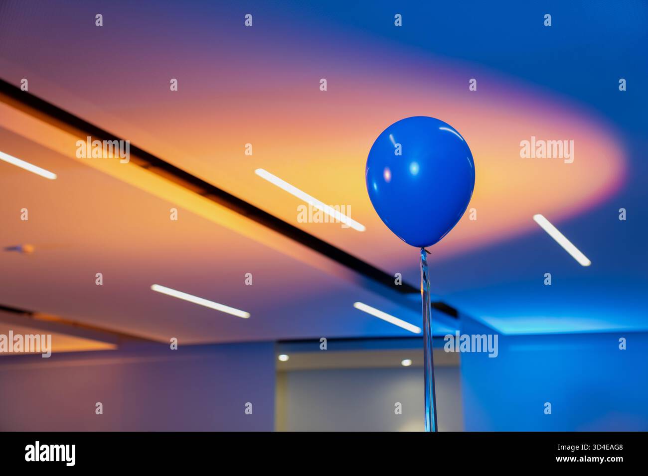 Mongolfiera blu che galleggia all'interno sotto una luce calda e fredda, concetto di celebrazione minimalista che rappresenta la decorazione di feste, il design di eventi, Happine Foto Stock
