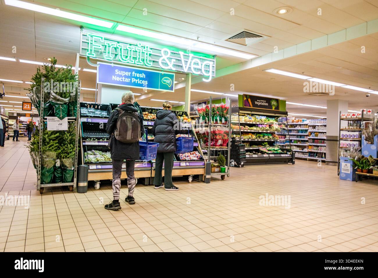 Londra Regno Unito, 10 novembre 2025, due donne anonime che esplorano l'esposizione del supermercato di frutta e verdura fresca Foto Stock