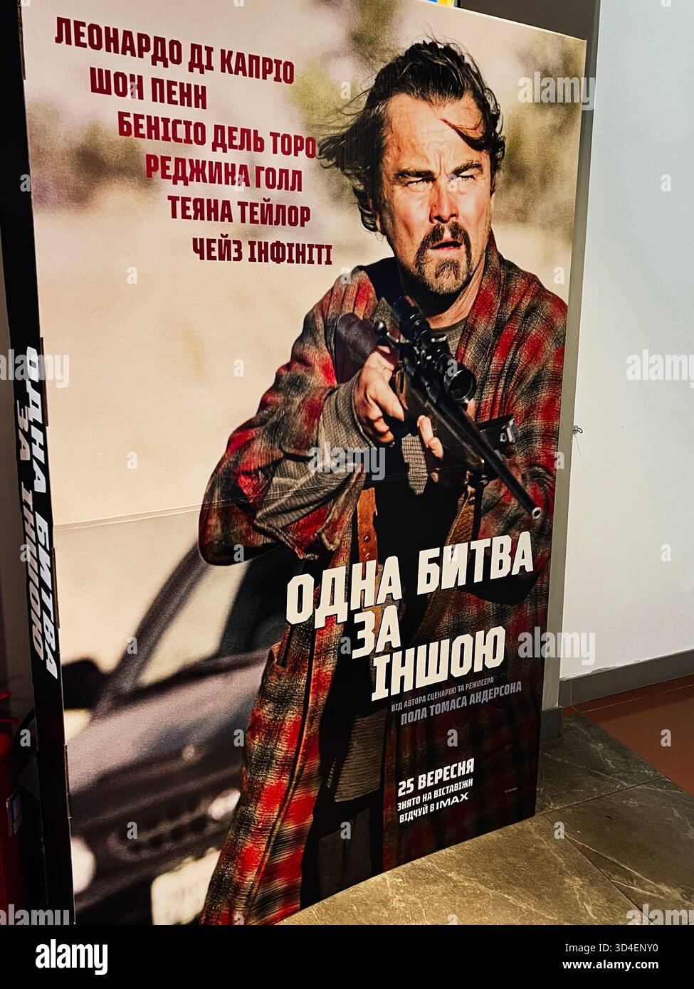 Kiev, Ucraina - 10 novembre 2025: Una battaglia dopo l'altra. Poster che mostra il robusto Leonardo DiCaprio che punta un fucile, un'intensa azione all'aperto Foto Stock
