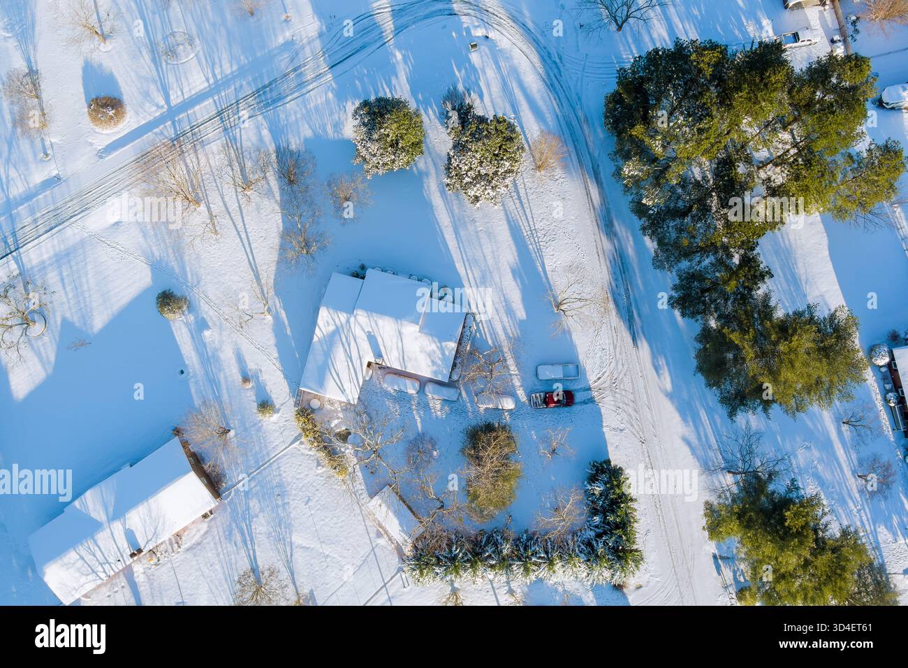 Vista aerea del paesaggio innevato con case, alberi, sentieri tortuosi nel tranquillo villaggio rurale americano Foto Stock