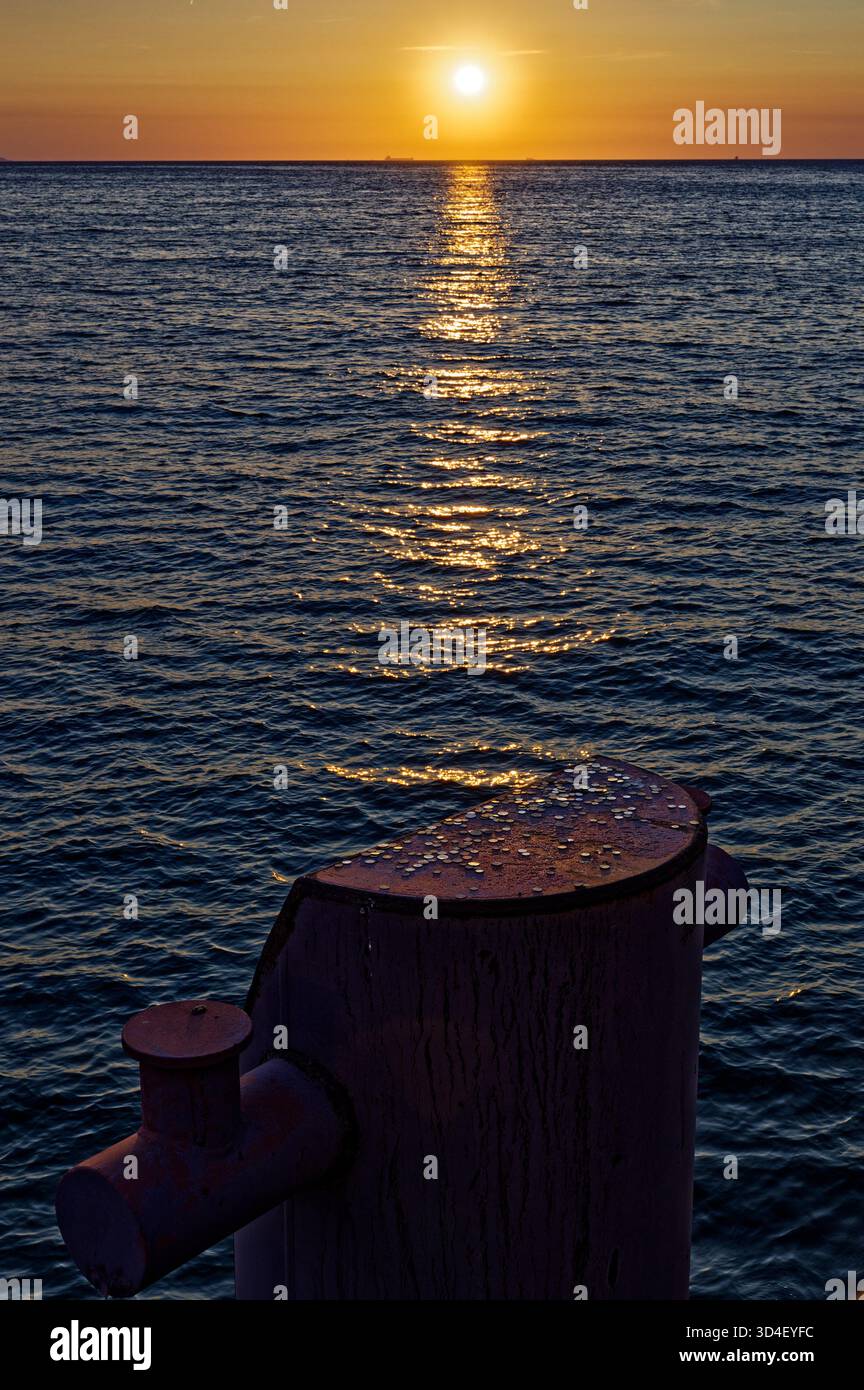 Tramonto dorato sul Mar Baltico visto dal molo. Foto Stock