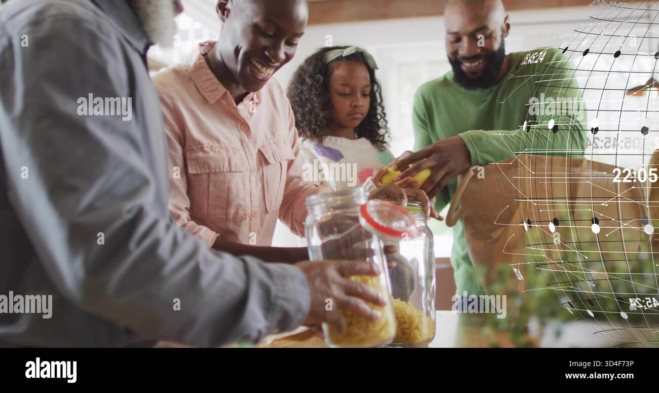 Versare la pasta secca in vasetti di vetro sulla griglia digitale del banco della cucina Foto Stock
