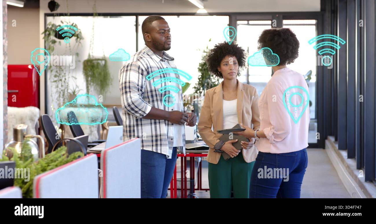 Discutere dei piani di condivisione dei team in ufficio tramite finestre con tablet, indossando abiti casual con icone cloud Foto Stock