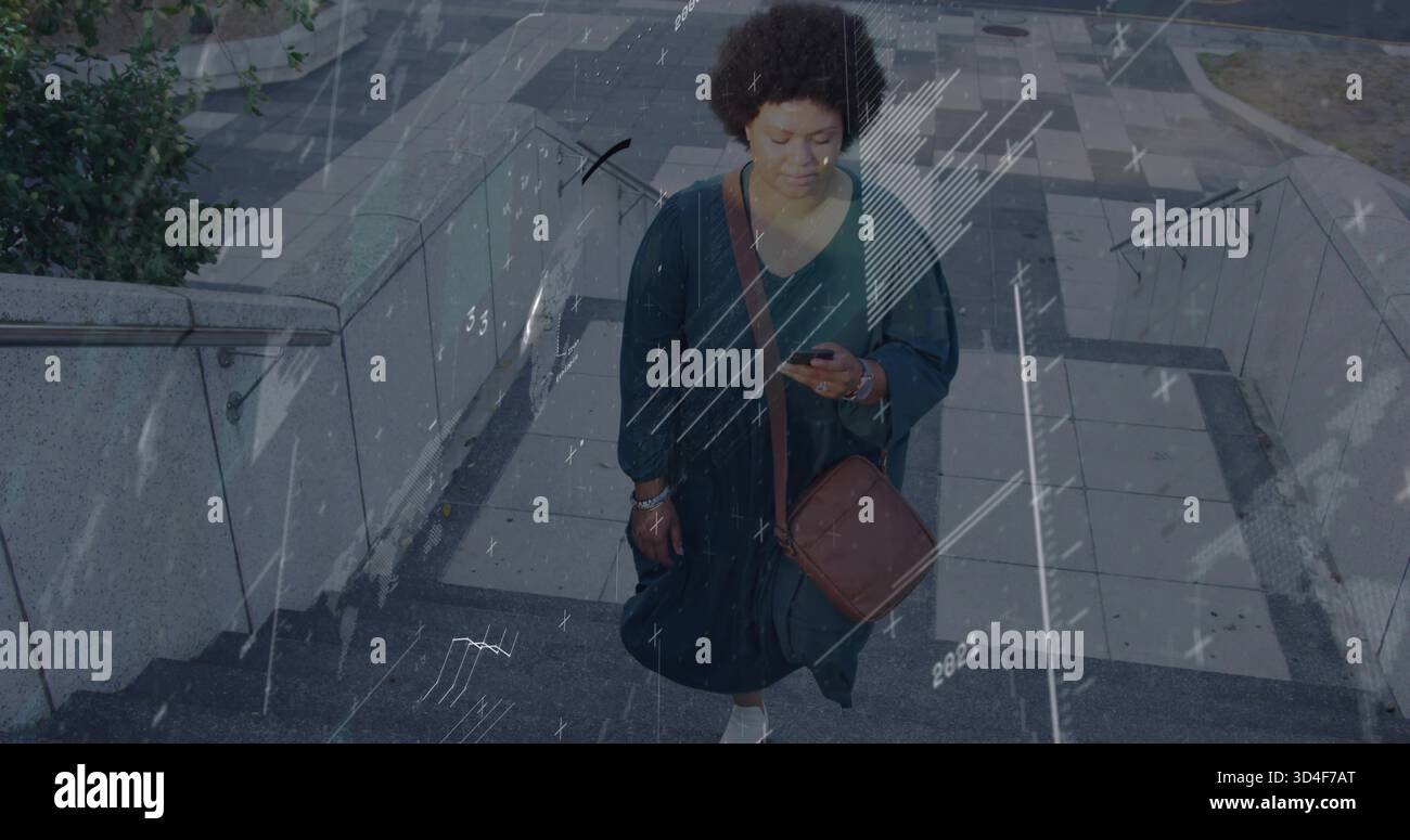 Donna adulta che cammina per le scale di cemento al plaza, indossa un abito scuro e tiene in mano lo smartphone Foto Stock
