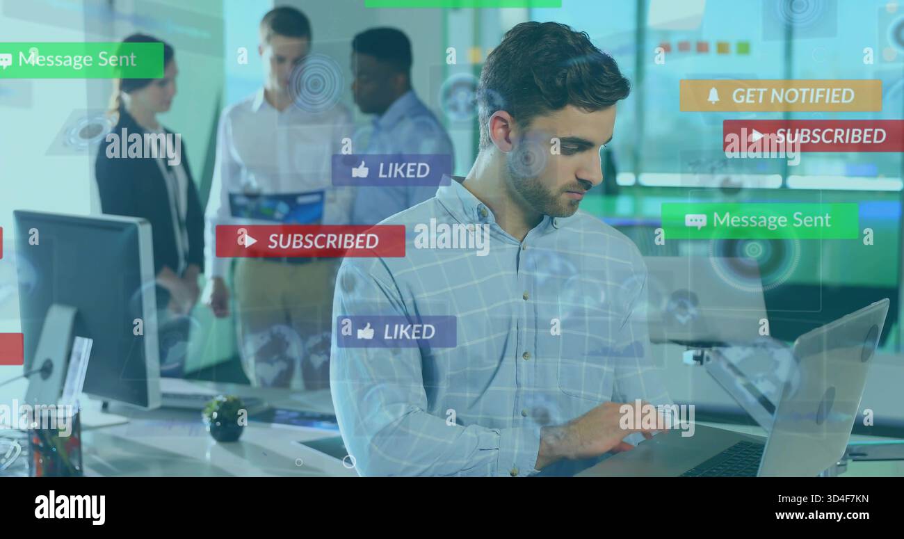 Lavoratore con barba che indossa una camicia blu che guarda il laptop in ufficio, con etichette social UI Foto Stock