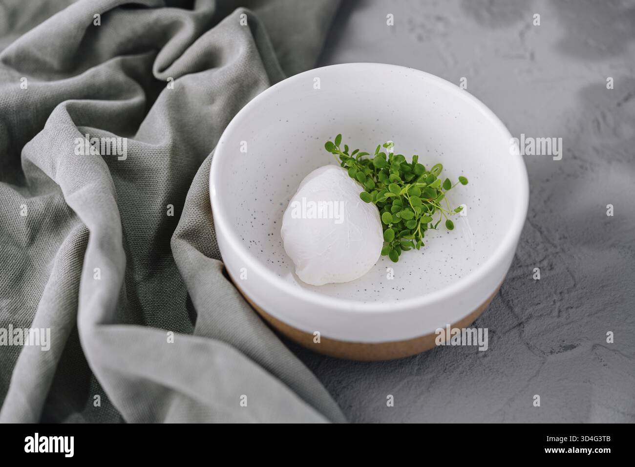 Cibo, uova in camicia sane guarnite con microverdure fresche servite in uno stile minimalista Foto Stock