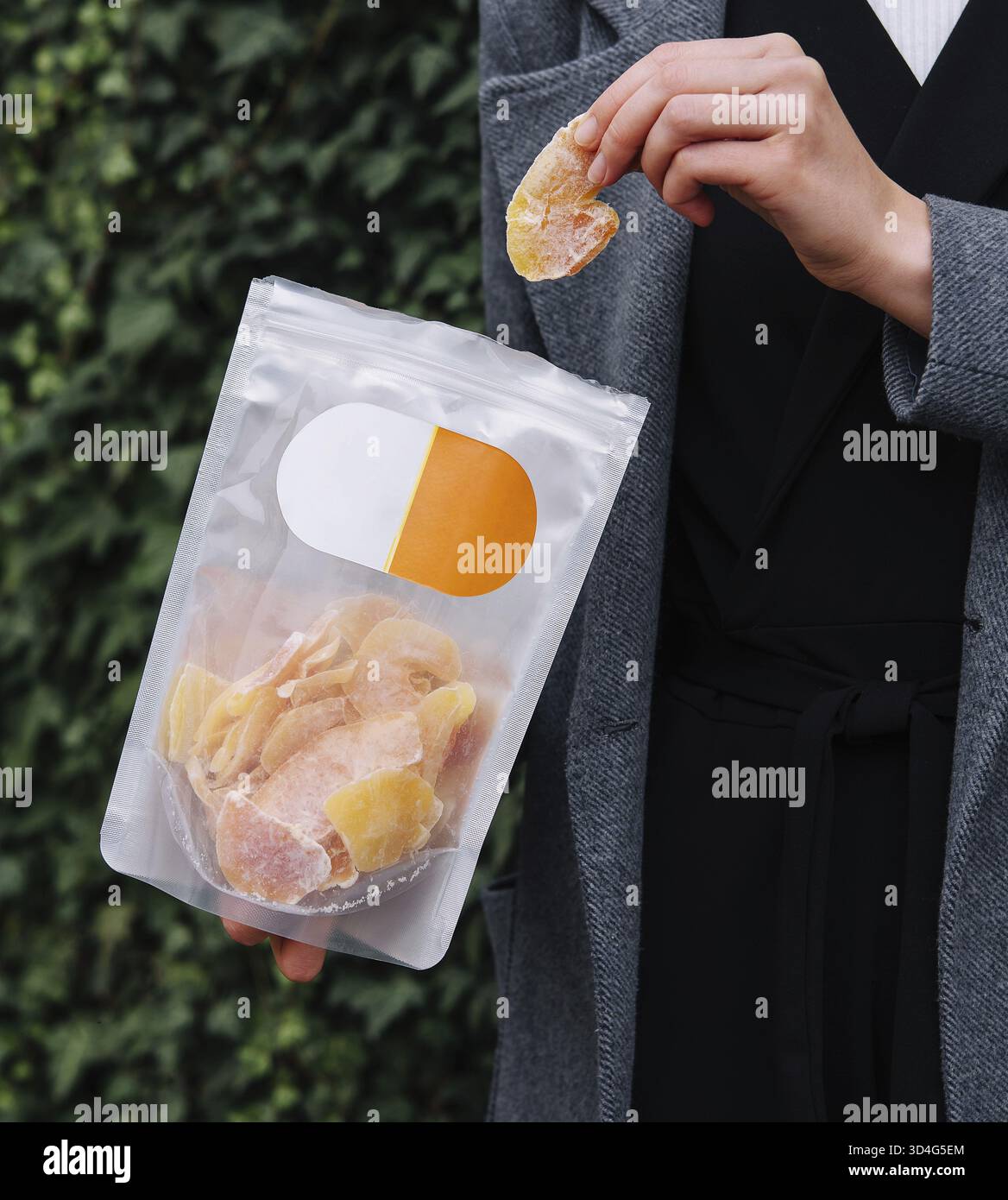 Cibo, ragazza che mangia fette di mango essiccate Foto Stock