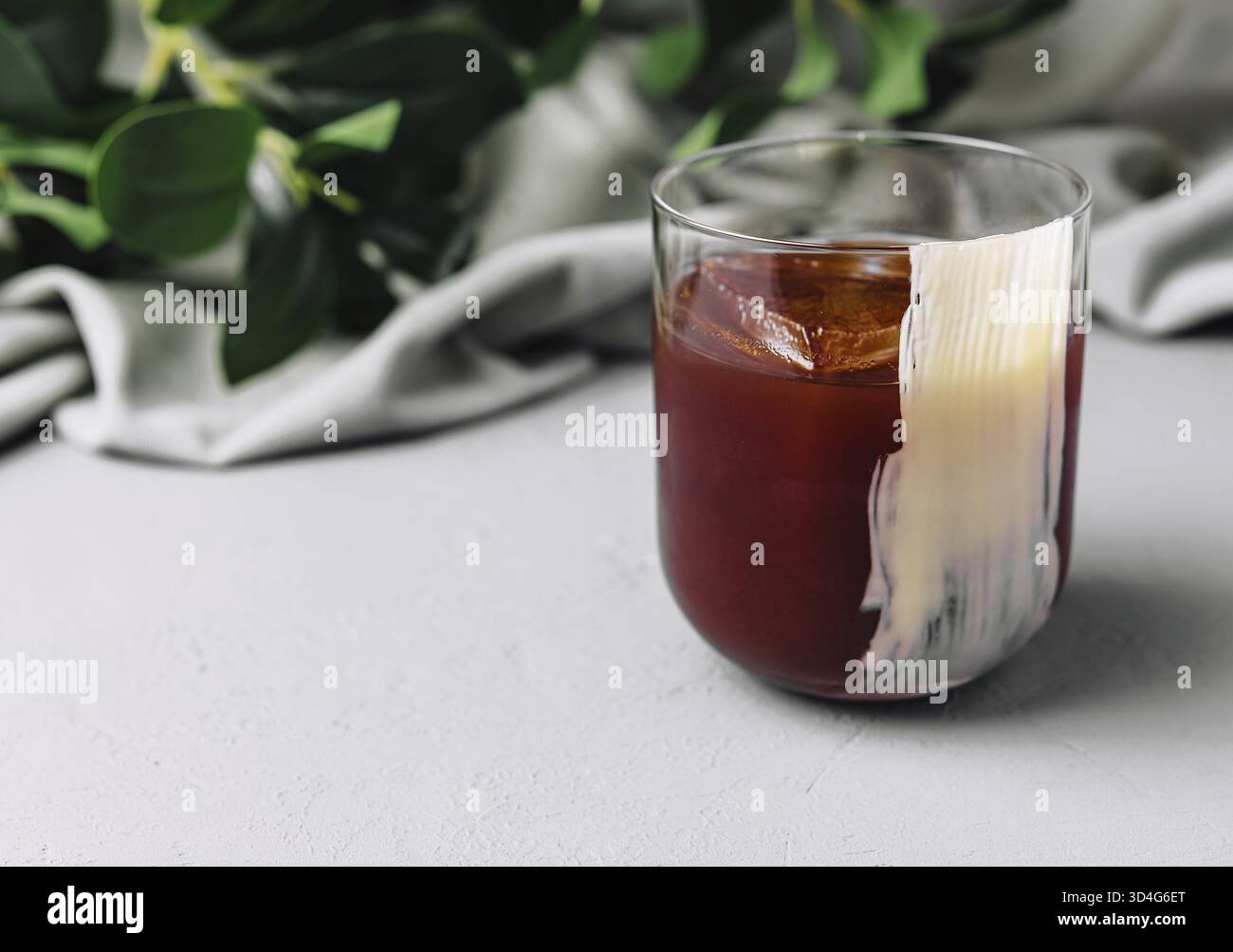 Cibo, bicchiere di caffè freddo con ghiaccio, posto elegantemente su un elegante ripiano Foto Stock