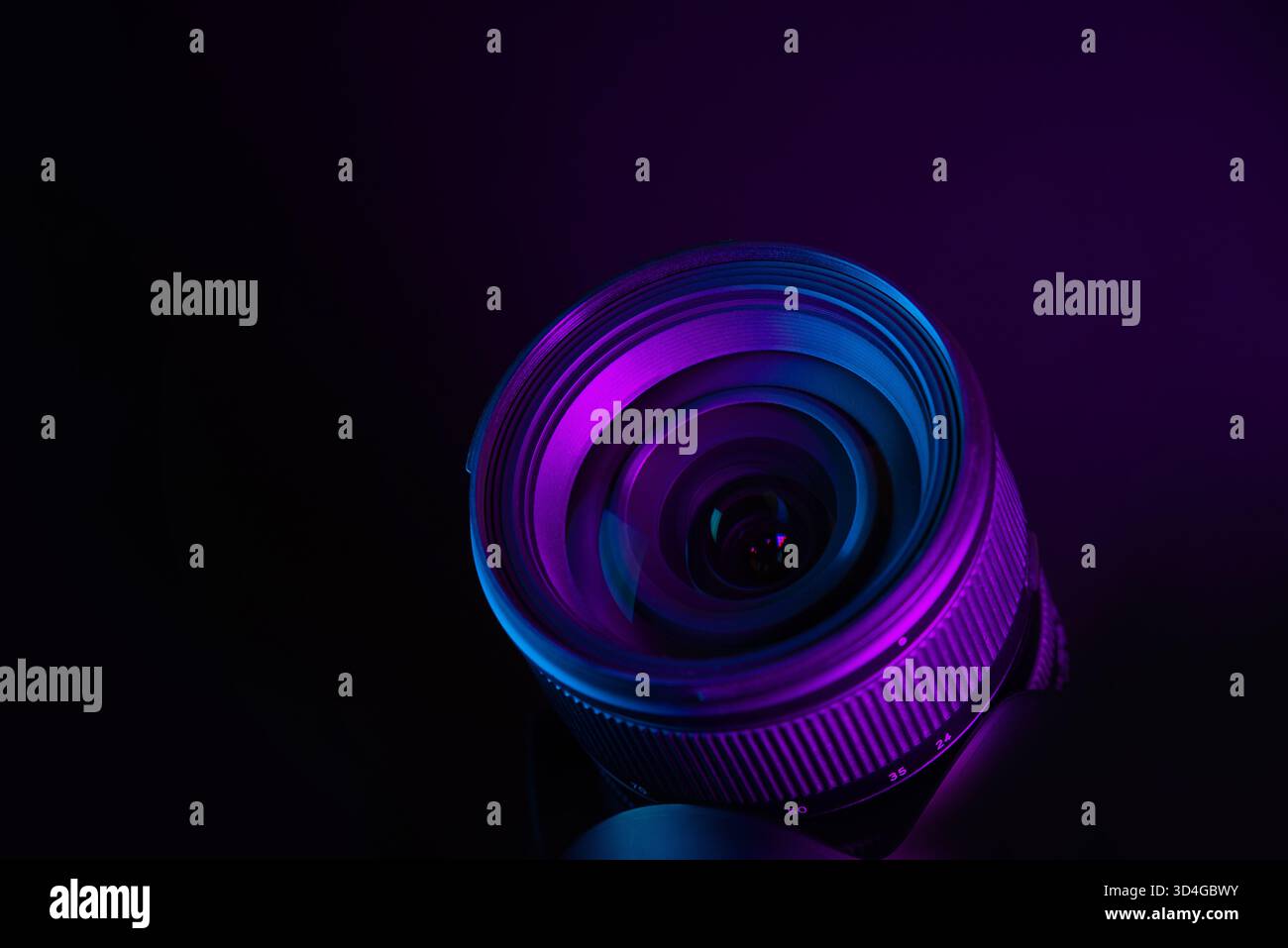 Obiettivo moderno sotto l'illuminazione viola e blu, sfondo futuristico dell'attrezzatura fotografica Foto Stock