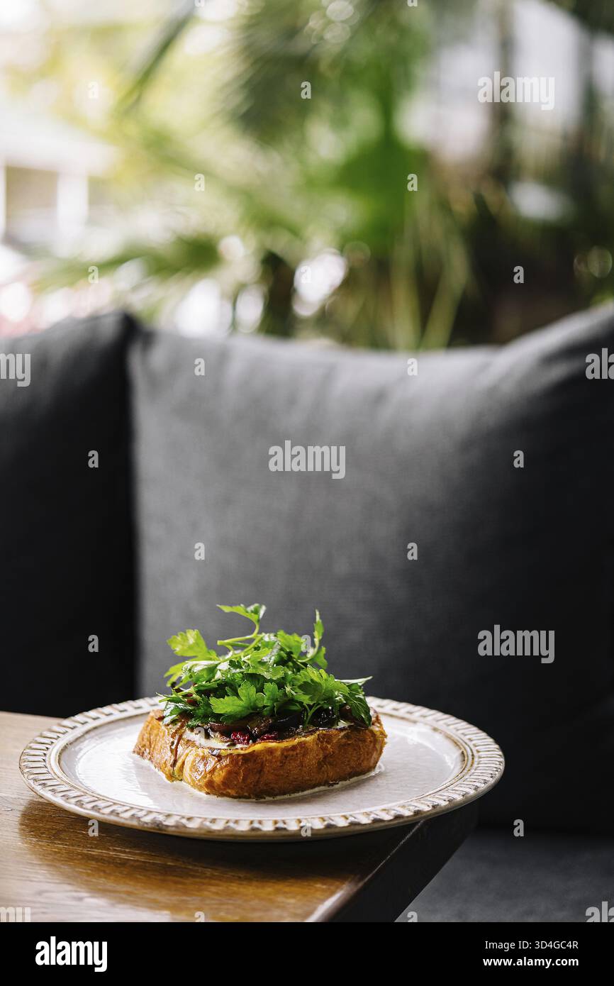 Cibo, delizioso panino a vista con erbe fresche, servito su un patio all'aperto Foto Stock