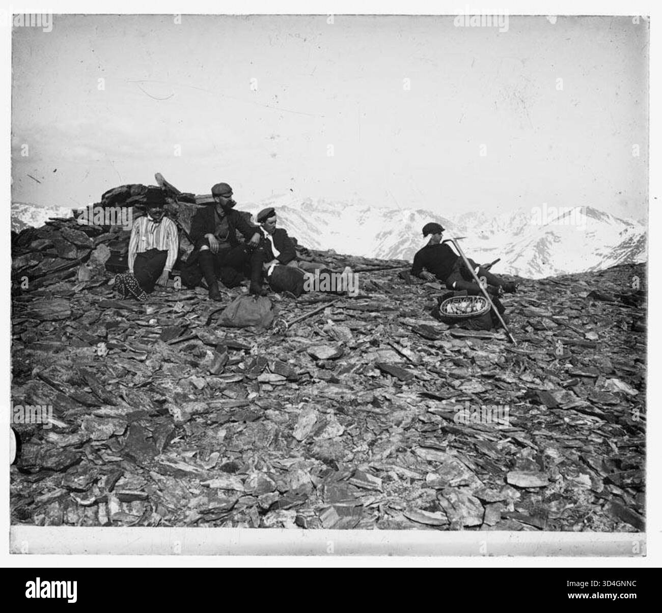 Gruppo di alpinisti su una cima con montagne innevate sullo sfondo, fotografato tra il 1897 e il 1925 da Antoni Bartumeus i Casanovas. Foto Stock