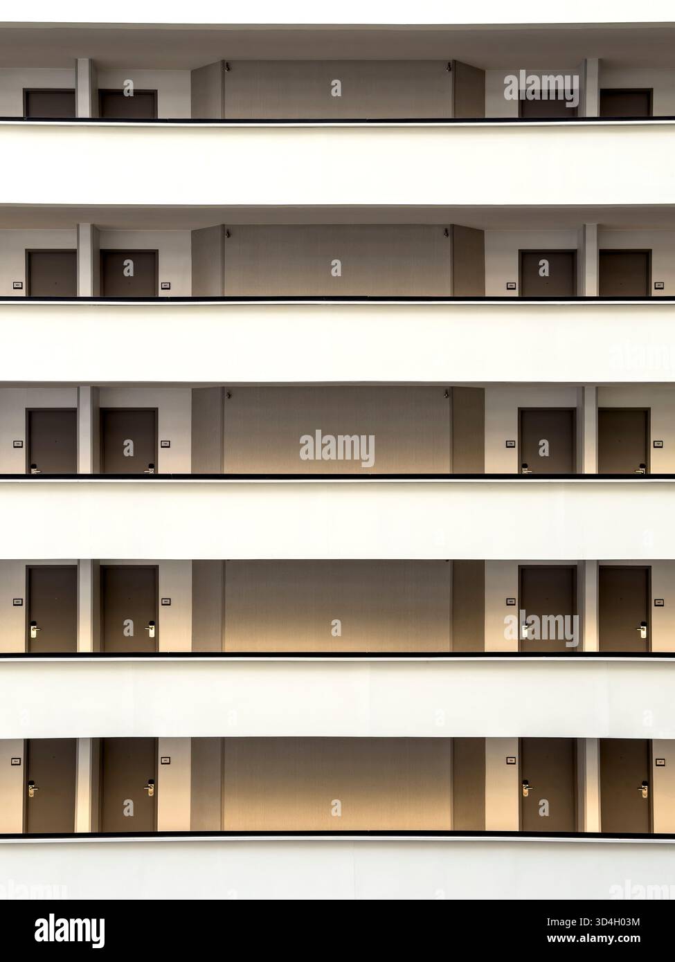Vista interna simmetrica dei corridoi e delle porte dell'hotel Foto Stock
