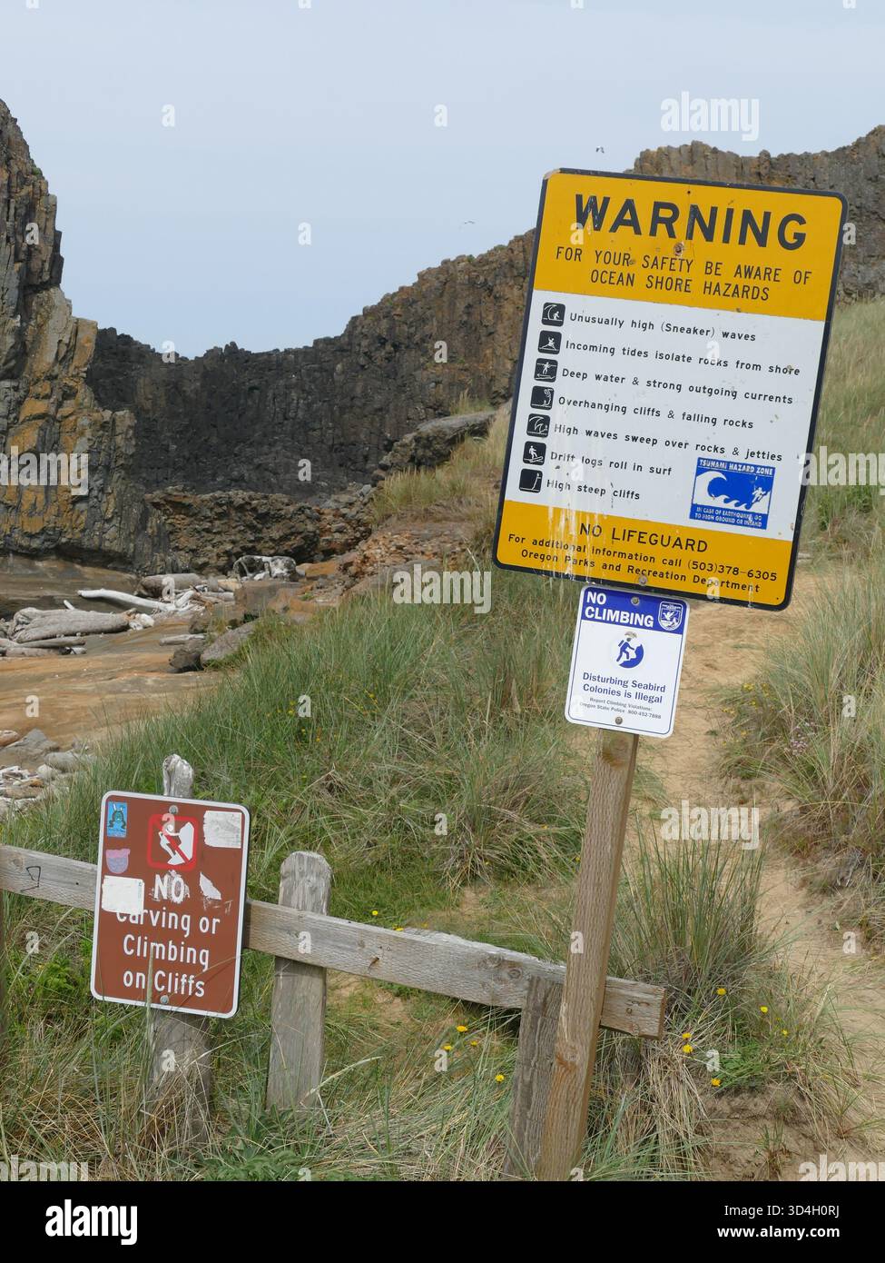 , Seal Rock, vicino a Newport, Oregon, numerosi cartelli segnaletici che elencano i pericoli della costa oceanica e le restrizioni per l'arrampicata si trovano di fronte a Seal Rock a Seal Roc Foto Stock