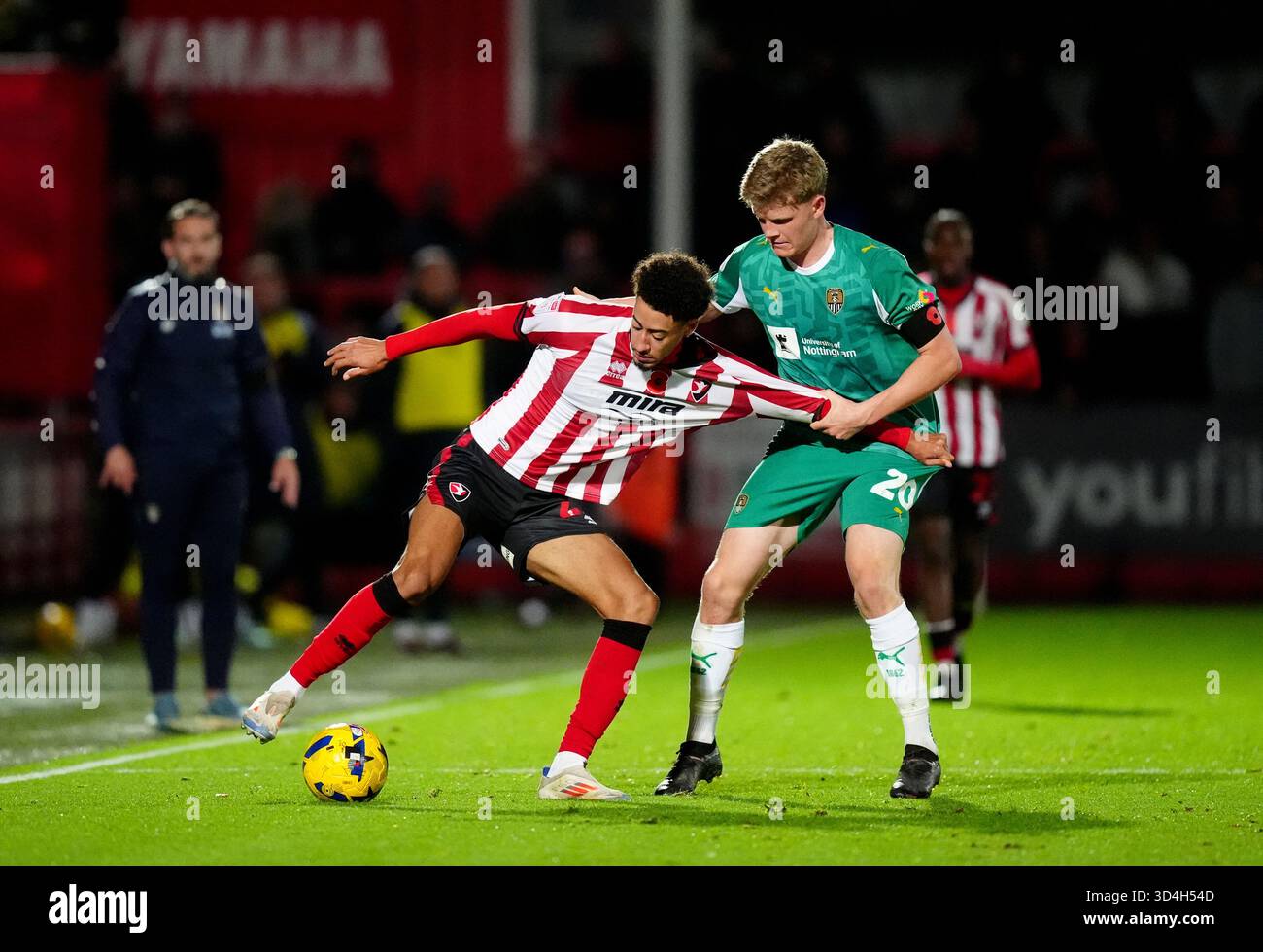 Jonathan Tomkinson (a sinistra) di Cheltenham Town e Scott Robertson (a destra) di Notts County combattono per il pallone durante la partita Sky Bet League Two all'EV Charger Points Stadium, Cheltenham Data immagine: Lunedì 10 novembre 2025. Foto Stock