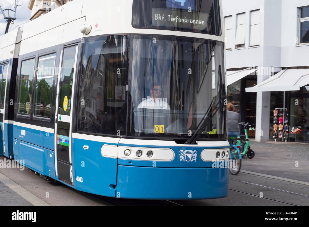 Moderno tram blu con autista nel centro di Zurigo, in Svizzera, trasporti pubblici urbani e vita cittadina. Foto Stock