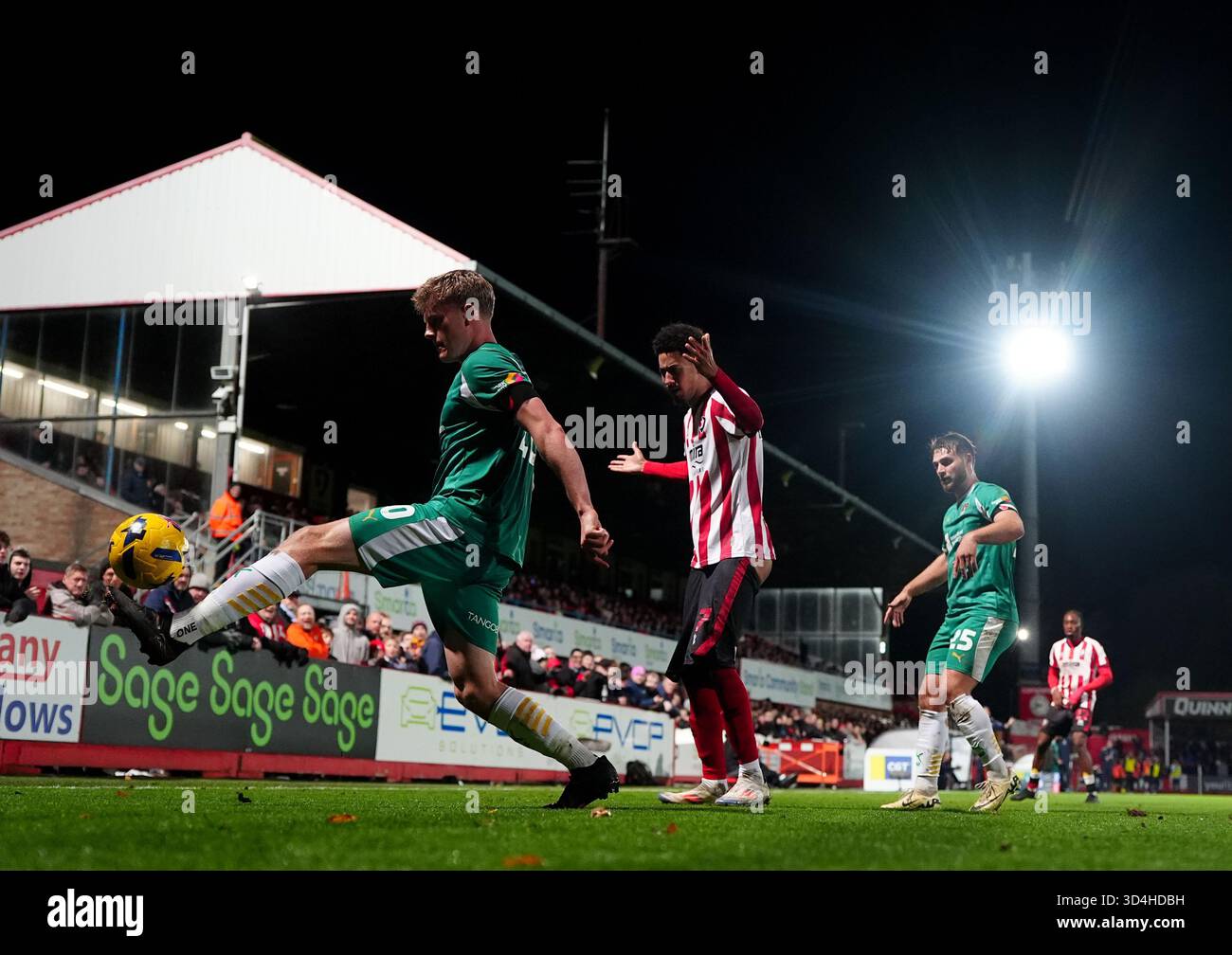 Scott Robertson (a sinistra) della contea di Notts e Jonathan Tomkinson (centro) del Cheltenham Town si battono per il pallone durante la partita Sky Bet League Two all'EV Charger Points Stadium, Cheltenham Data immagine: Lunedì 10 novembre 2025. Foto Stock