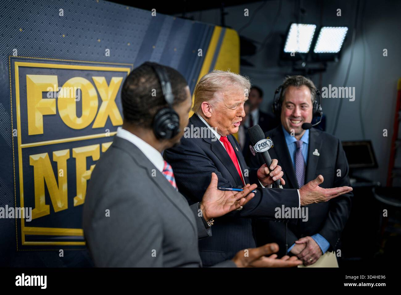 Landover, Stati Uniti. 9 novembre 2025. Il presidente degli Stati Uniti Donald Trump, al centro, si unisce agli atleti Kenny Albert, a destra, e Jonathan Vilma, a sinistra, durante la trasmissione in diretta alla cabina della Fox NFL mentre i Washington Commanders affrontano i Detroit Lions al Northwest Stadium, 9 novembre 2025 a Landover, Maryland. Credito: Daniel Torok/White House Photo/Alamy Live News Foto Stock