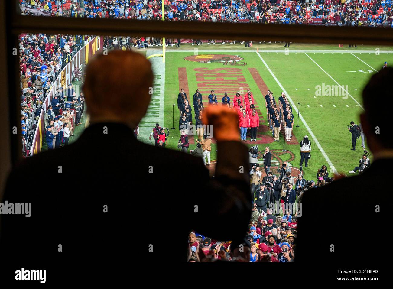 Landover, Stati Uniti. 9 novembre 2025. Il presidente degli Stati Uniti Donald Trump, a sinistra, ha tenuto il pugno durante una cerimonia di "salute to Service" all'intervallo in onore dei membri del servizio in servizio attivo, dei veterani e delle loro famiglie in vista del Veterans Day al Northwest Stadium, 9 novembre 2025 a Landover, Maryland. La squadra locale, i Washington Commanders, giocavano con i Detroit Lions. Credito: Daniel Torok/White House Photo/Alamy Live News Foto Stock
