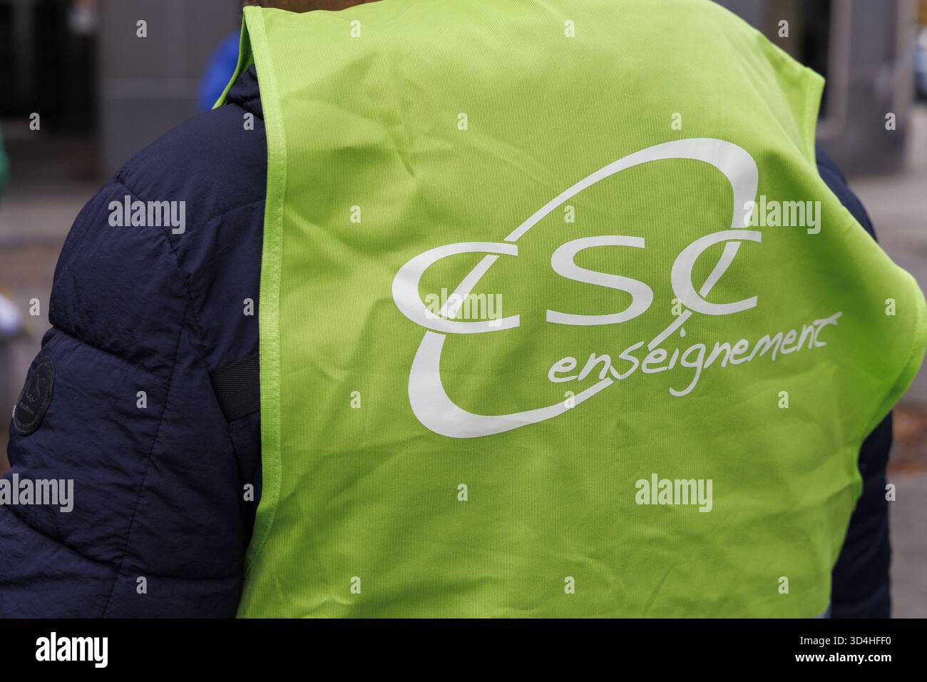 Bruxelles, Belgio. 10 novembre 2025. Chiudere il logo del gilet CSC Enseignement union in occasione di un'azione organizzata da una delegazione di insegnanti in occasione della giornata dello sciopero dell'istruzione, a Bruxelles, lunedì 10 novembre 2025. Una corona sarà posata (9:30) di fronte all'edificio della Federazione Vallonia-Bruxelles in memoria dei colleghi sacrificati dalle misure governative. BELGA FOTO NICOLAS MAETERLINCK credito: Belga News Agency/Alamy Live News Foto Stock