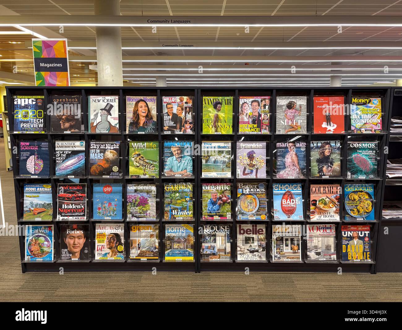 Espositore di riviste in una moderna biblioteca pubblica, in Australia, con un'ampia selezione di periodici attuali che coprono vari generi come notizie, vita Foto Stock