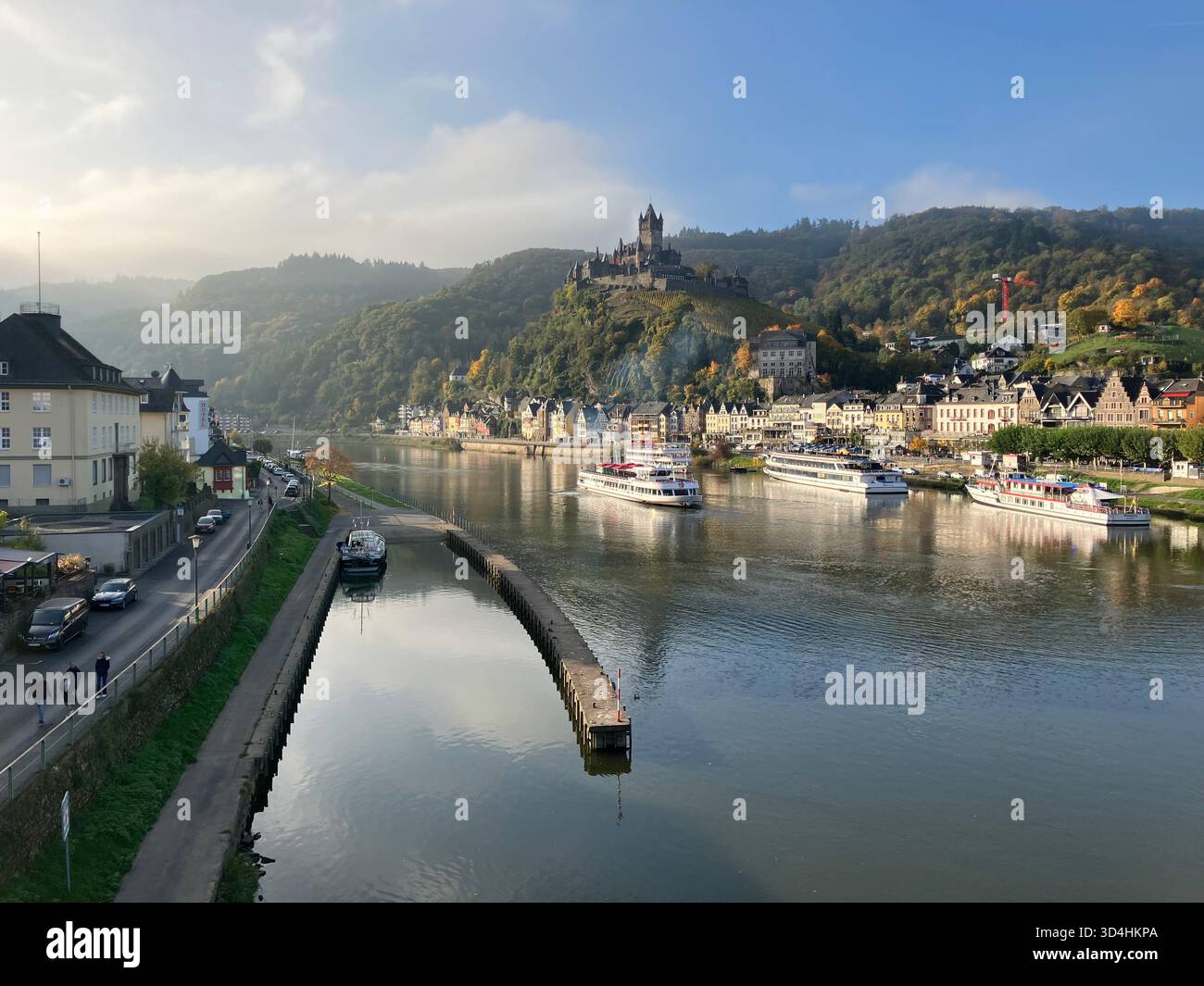 Il castello di Reichsburg Cochem si affaccia sulla città di Cochem e sulle barche sul fiume Mosella in una mattinata serena in Renania-Palatinato, Germania. - Immagine stock catturata con smartphone