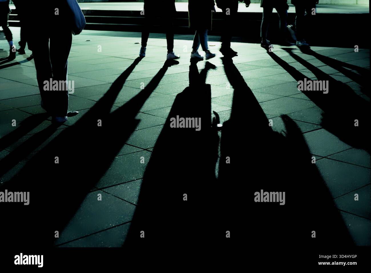 Ombre di gente che cammina sul marciapiede di notte. Foto Stock
