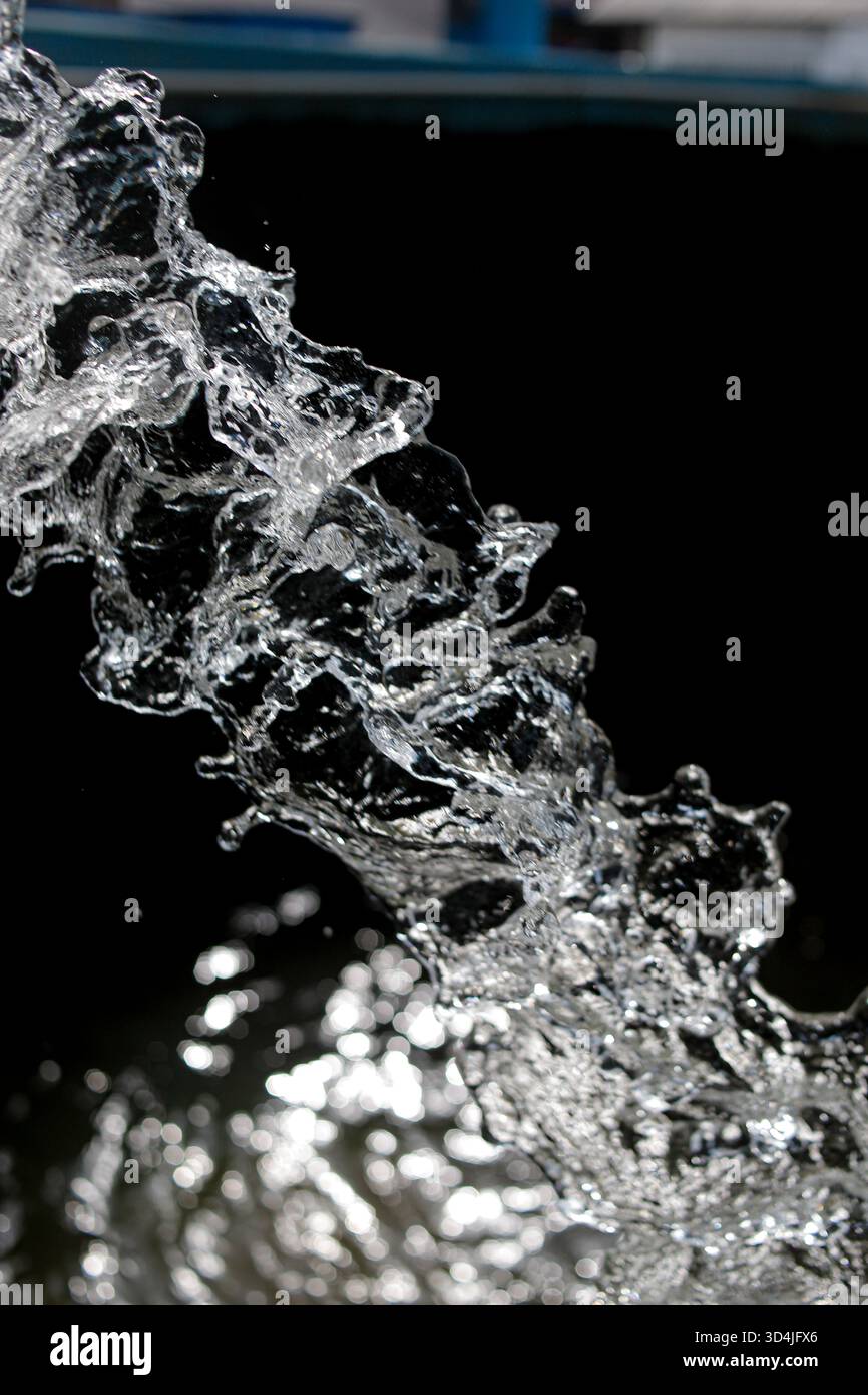 consistenza astratta di spruzzi d'acqua sfocati su sfondo scuro per un concetto di freschezza Foto Stock