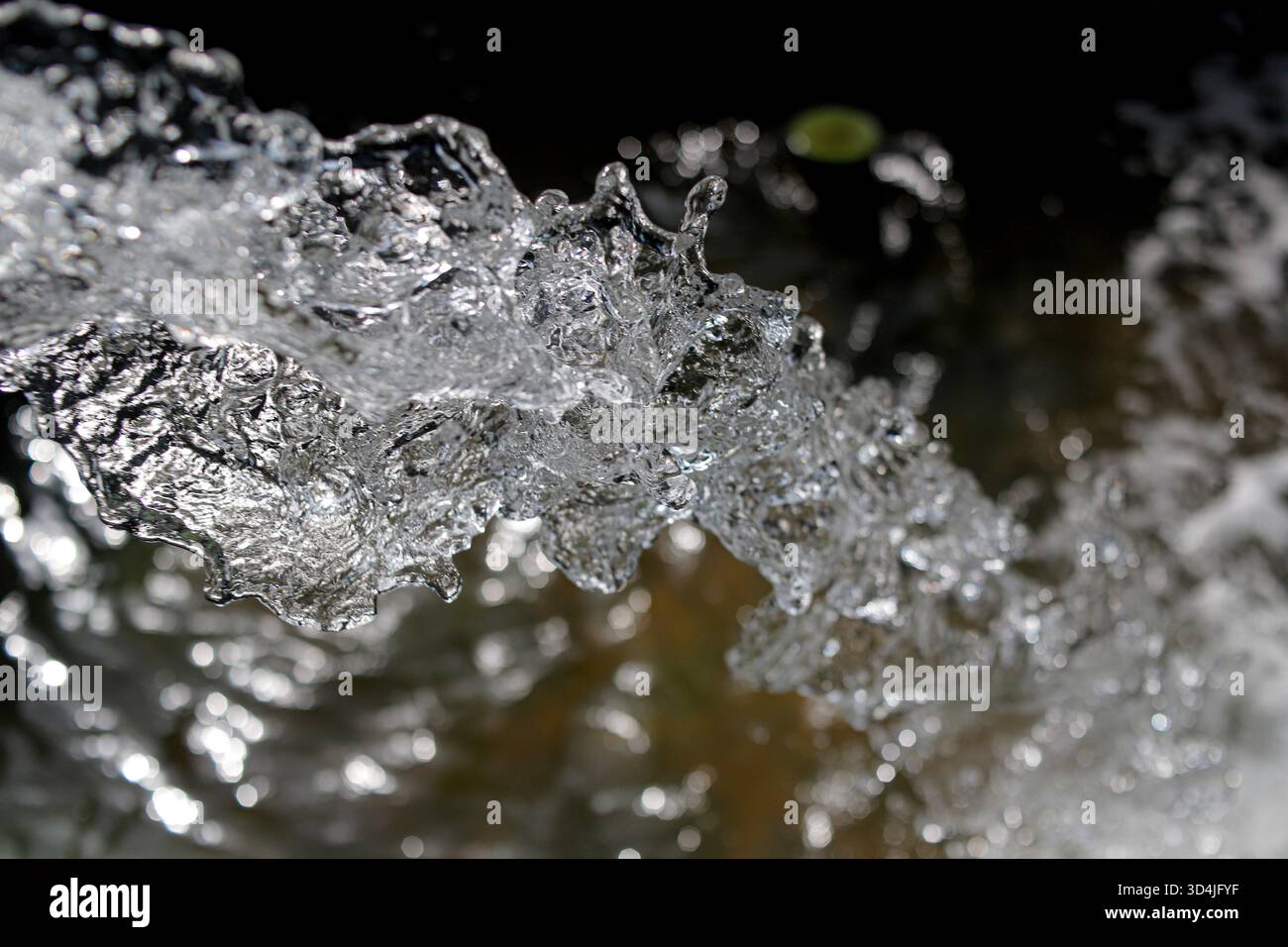 consistenza astratta di spruzzi d'acqua sfocati su sfondo scuro per un concetto di freschezza Foto Stock