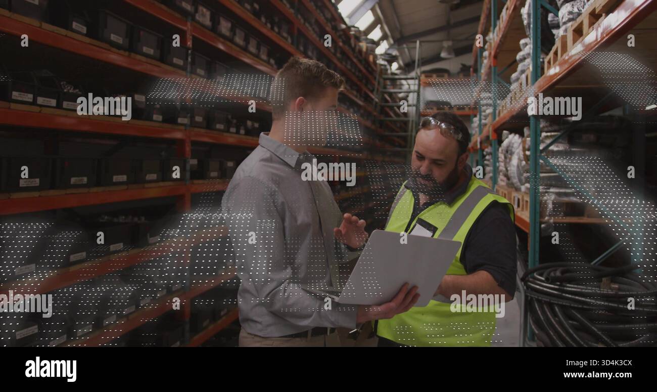 Con un tablet, due uomini che indossano una camicia e un giubbotto di sicurezza che ispezionano i contenitori etichettati nel magazzino Foto Stock