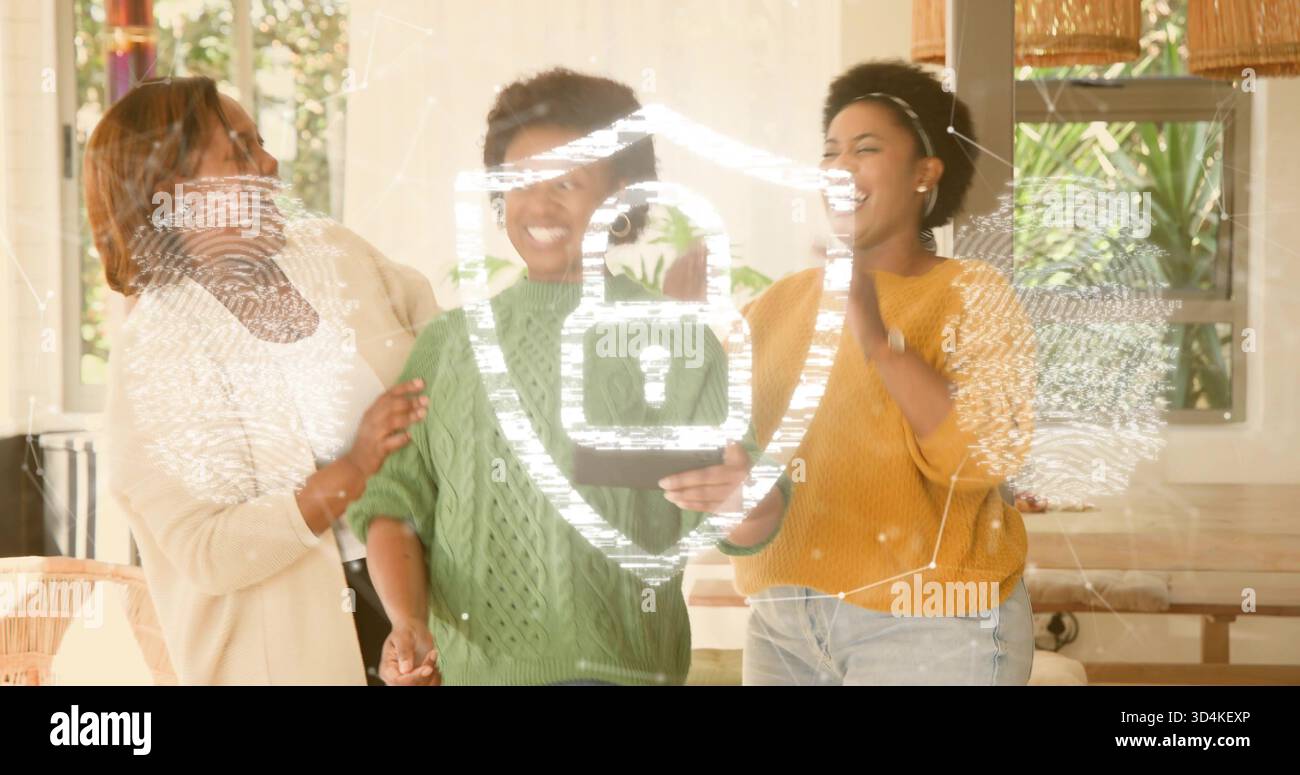 Tenendo in mano un tablet, tre donne che ridono, indossano maglioni in maglia a cavo a casa con rivestimento protettivo Foto Stock