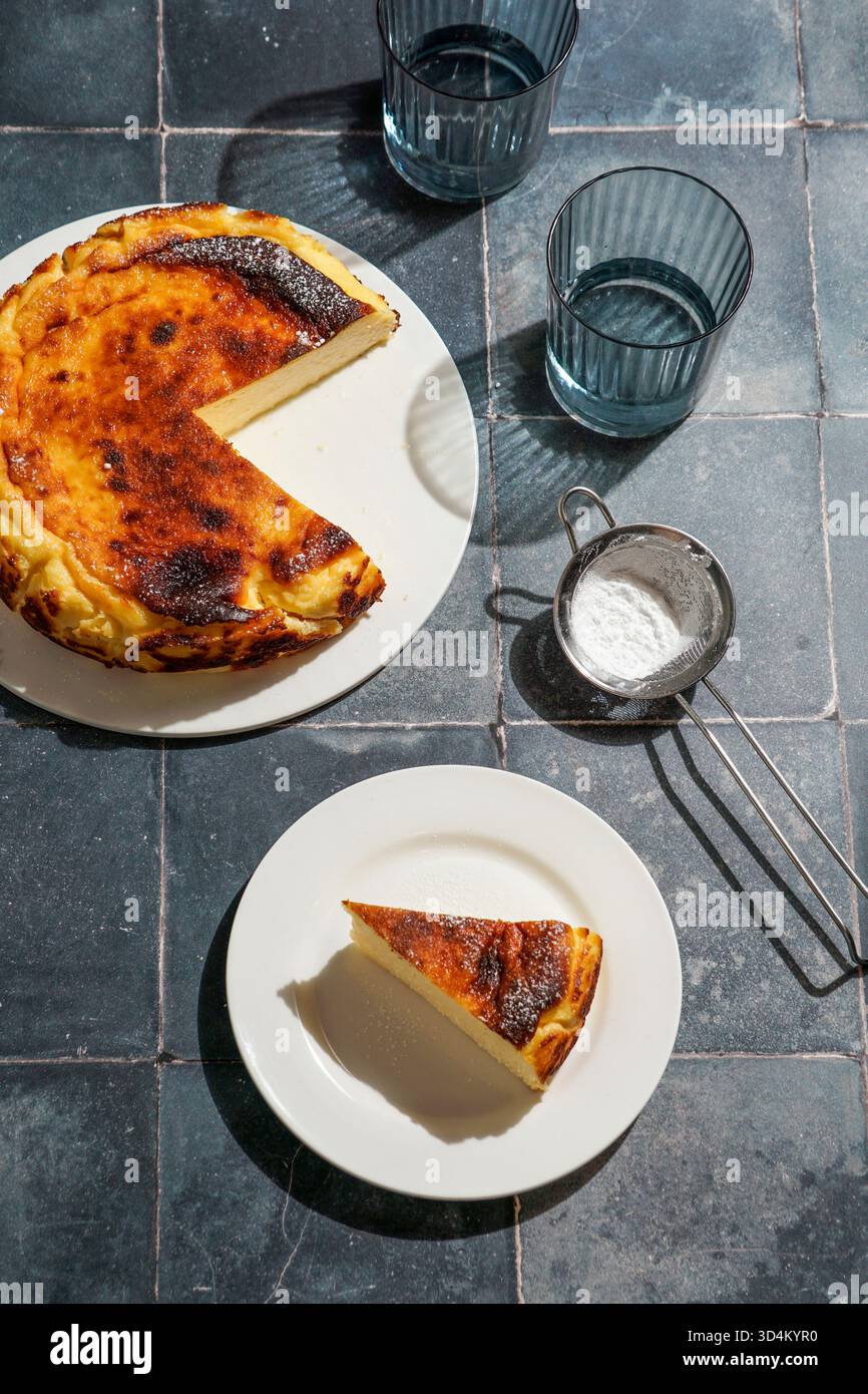 Cheesecake basca alla luce del sole su una tovaglia di lino Foto Stock