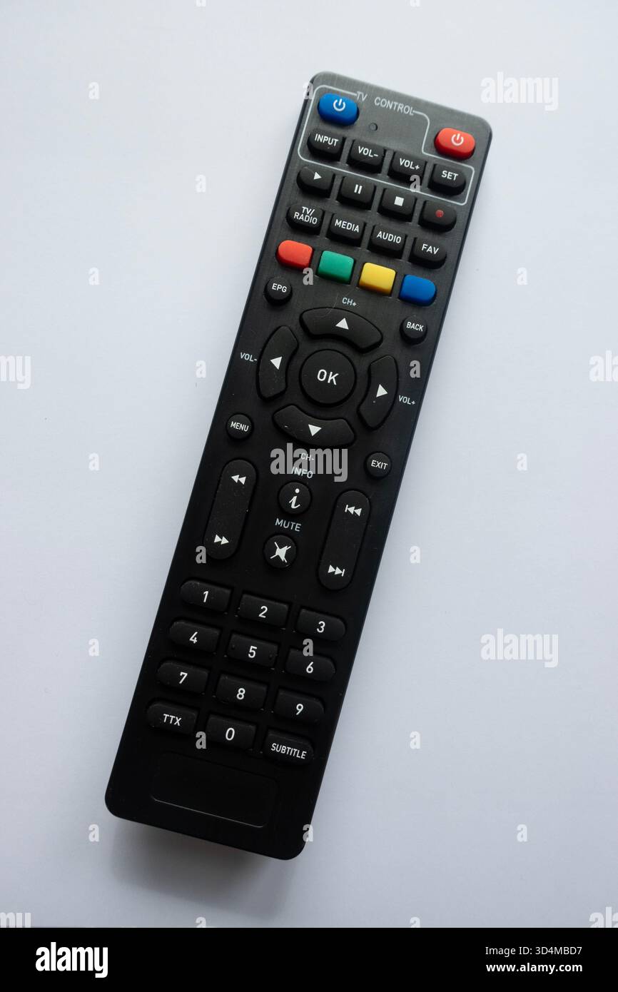 Telecomando TV nero visualizzato dall'alto su sfondo bianco, con tasti colorati e layout Foto Stock