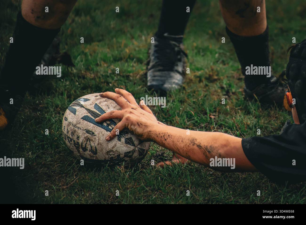 Immagini di giocatori di rugby che calciano una palla e segnano una prova su un campo all'aperto Foto Stock