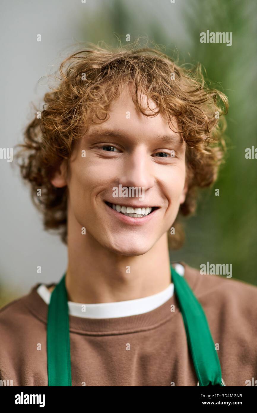 Il giovane con i capelli ricci esprime gioia mentre è impegnato in attività creative in un ambiente rilassato. Foto Stock