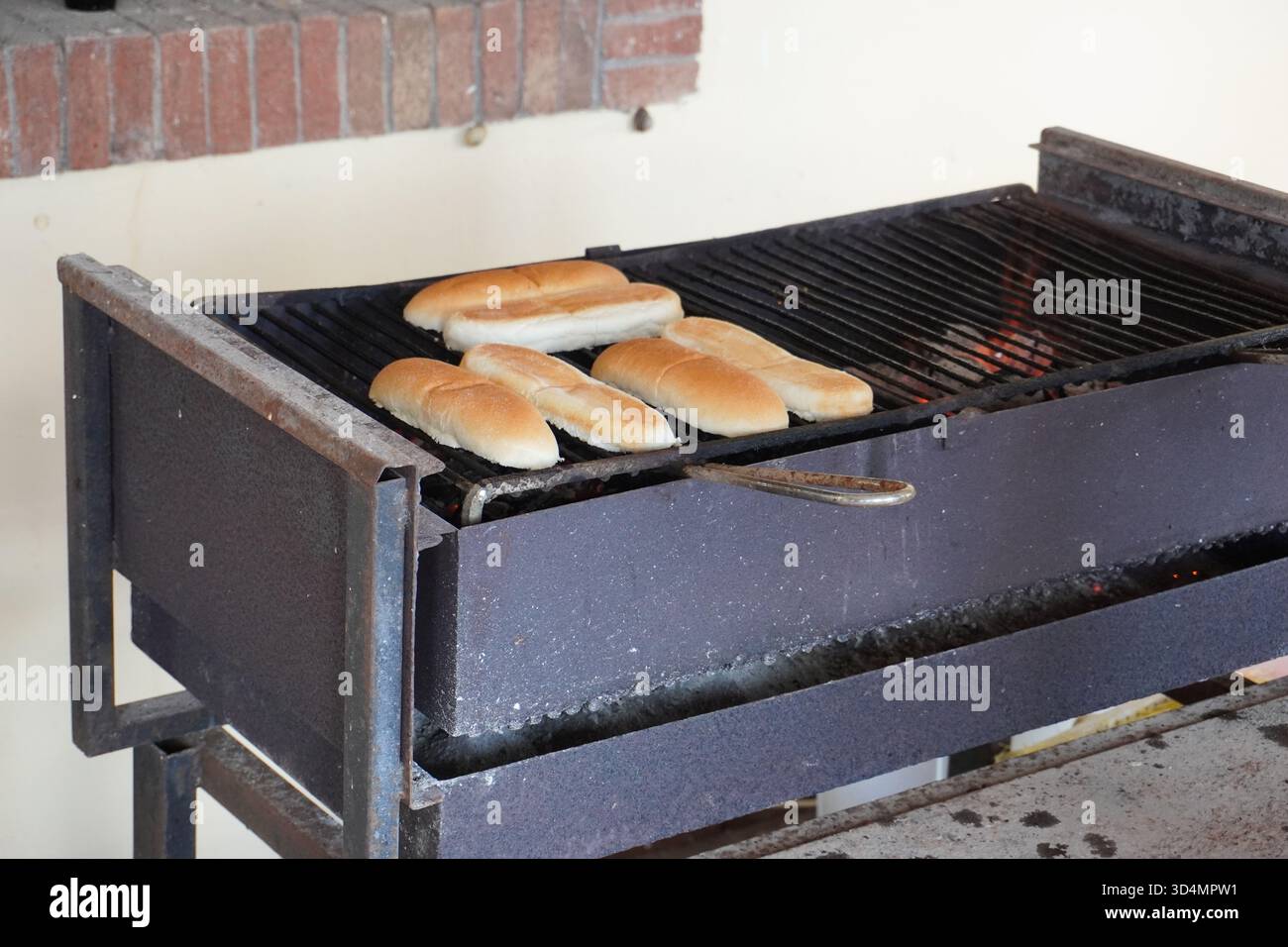 Cucinare hot dog. Panini per hot dog grigliati al barbecue all'aperto. Preparare deliziosi pasti estivi o autunnali alla griglia. Pasto di cucina alla riunione. Foto Stock