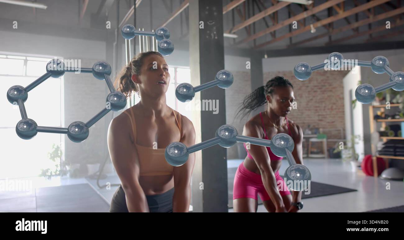 Far oscillare due donne in reggiseni sportivi usando manubri su tappetini in loft studio, sovrapposizioni molecolari Foto Stock