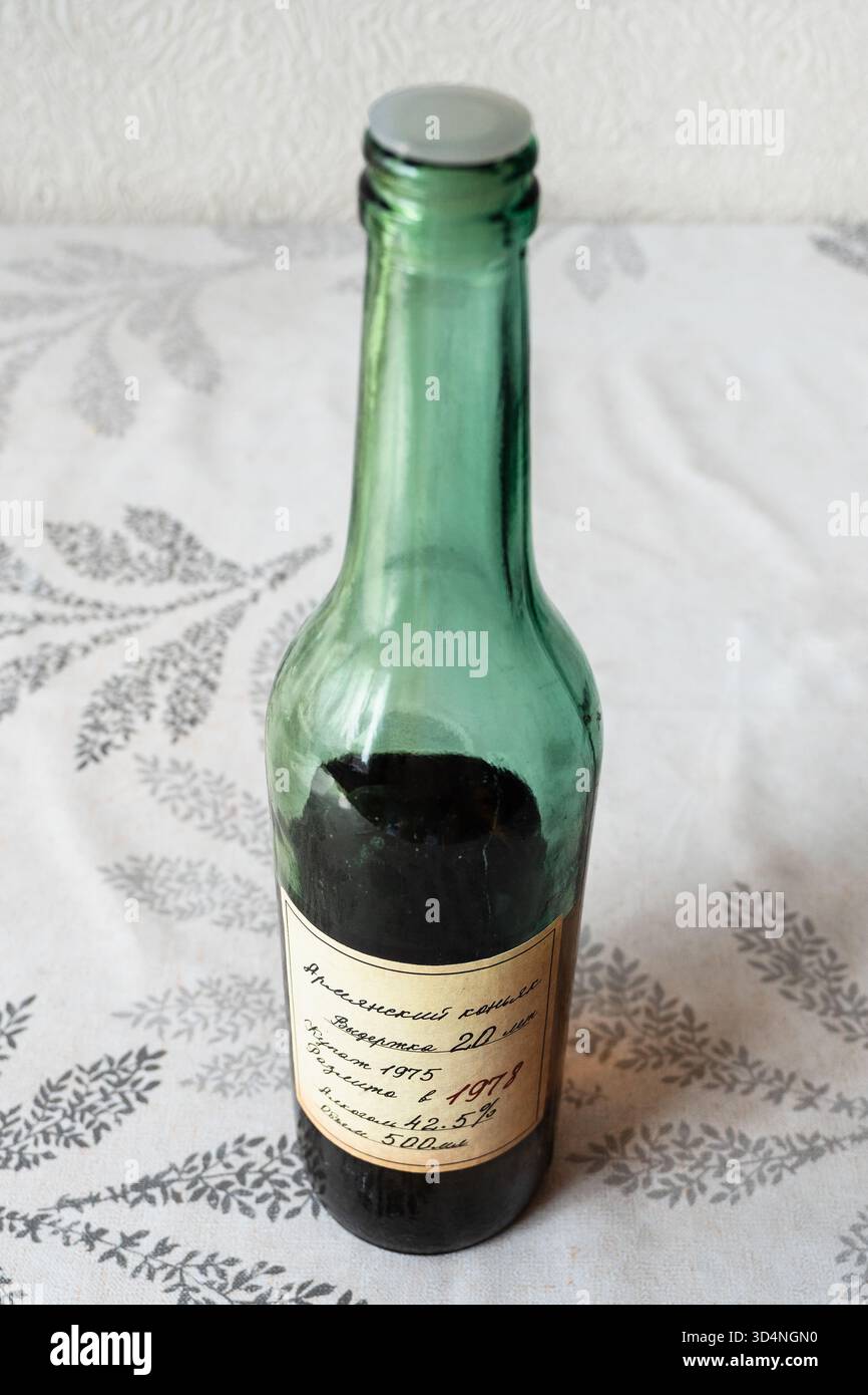 Erevan, Armena - 31 luglio 2025: Bottiglia di vetro sovietica chiusa e mezza ubriaca di cognac armeno (brandy), invecchiata per almeno 20 anni, miscelata nel 1975, bottiglia Foto Stock
