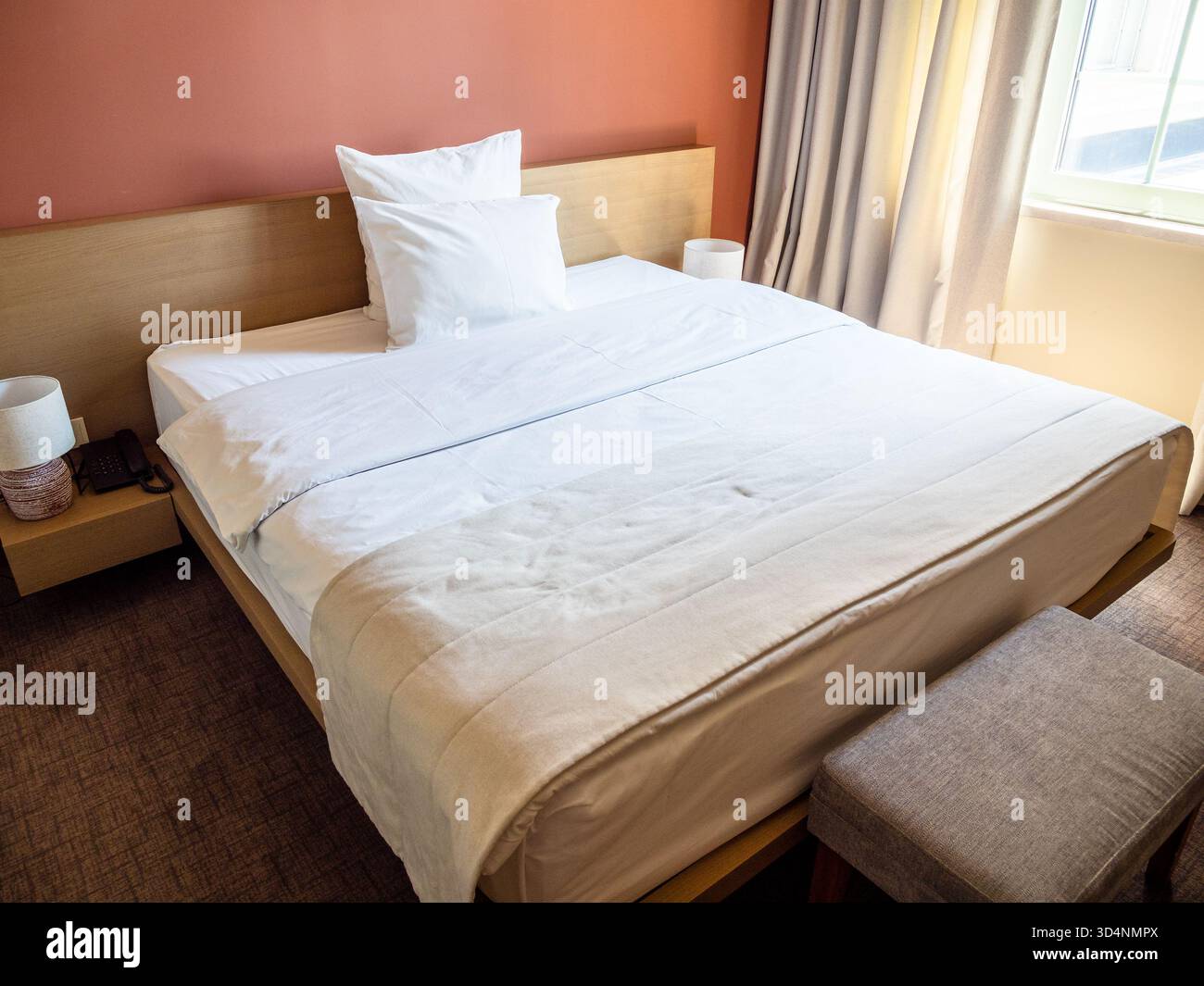 letto matrimoniale con lenzuola bianche e due cuscini in un piccolo appartamento Foto Stock