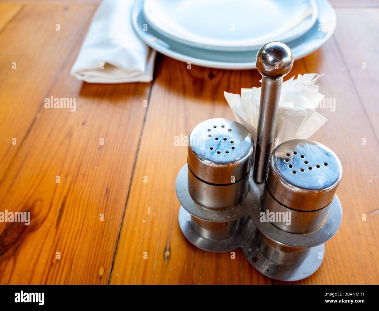 set di spezie di sale e pepe d'acciaio con stuzzicadenti su un tavolo da pranzo in legno Foto Stock