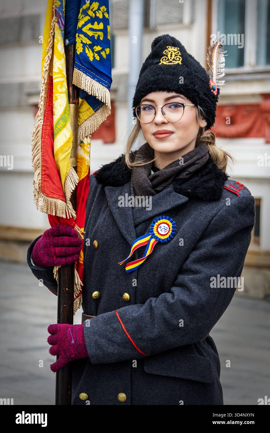 Persona in abito cerimoniale con nastro tricolore e bandiera durante la giornata nazionale rumena a Bacău. Foto Stock
