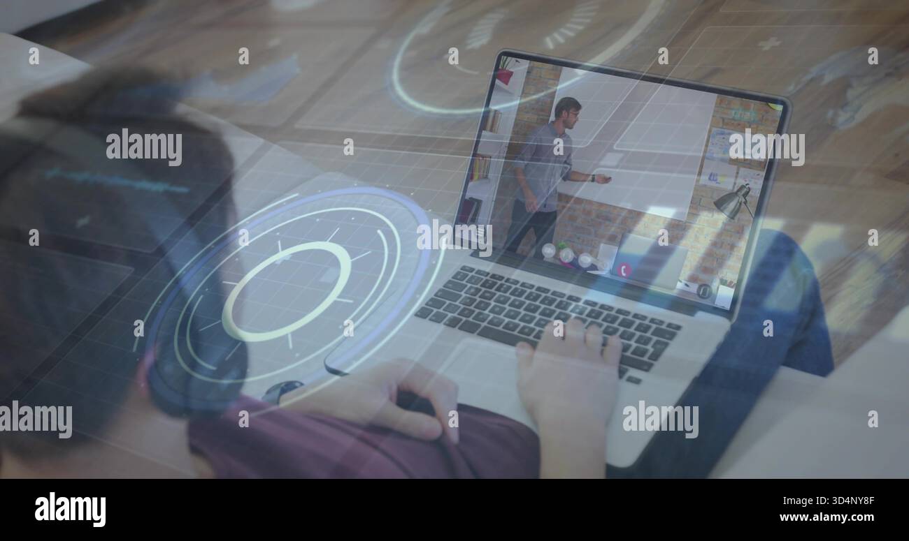 Utilizzo del computer portatile sul divano adolescente indossando una cuffia sopra l'orecchio per visualizzare i gesti dell'ospite sugli ologrammi dello schermo Foto Stock