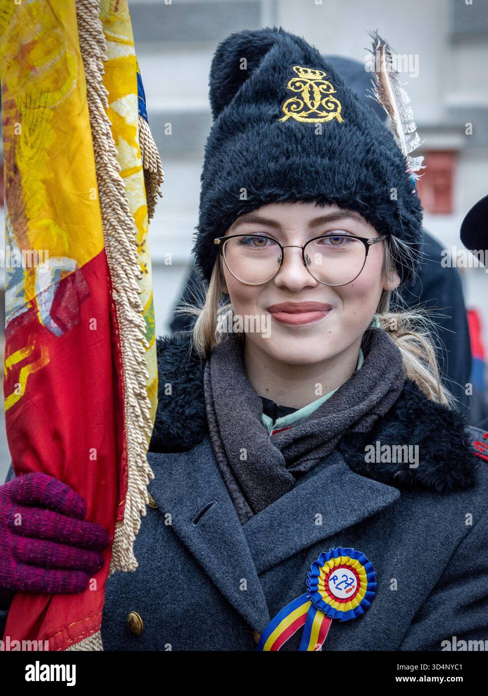 Persona in uniforme cerimoniale che tiene bandiere durante la festa nazionale rumena a Bacău. Foto Stock