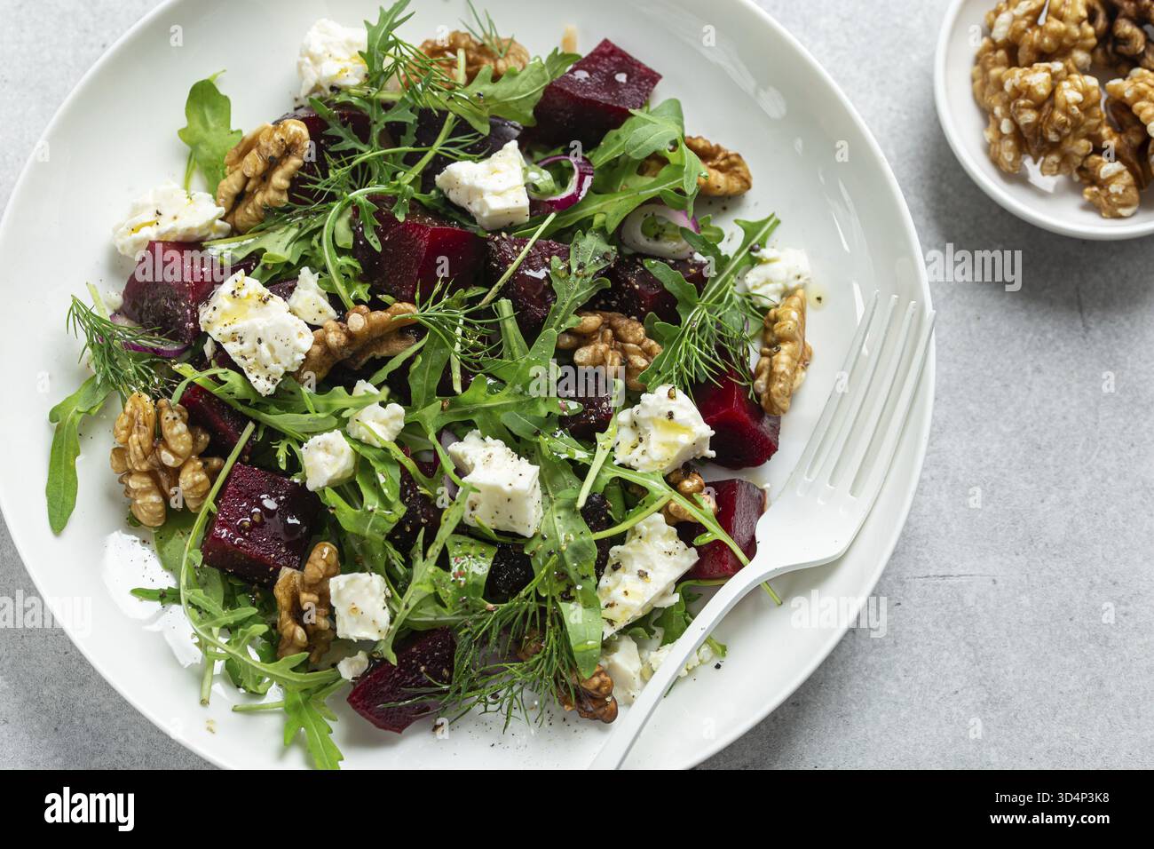 Cibo, barbabietola fresca e sana, insalata di feta e noci su piatto bianco, vista dall'alto, spazio copia Foto Stock