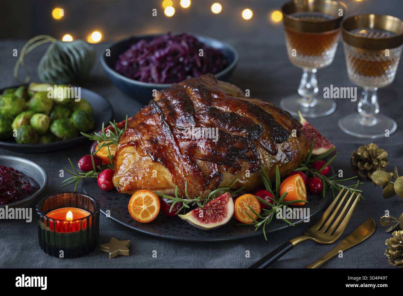 Cibo, tavola natalizia. Deliziosa corona di tacchino arrosto con pancetta per la cena delle vacanze. Sfondo scuro Foto Stock