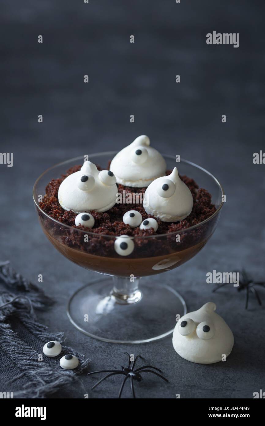 Cibo, dessert con budino di cioccolato e meringa fantasmi per la festa di Halloween Foto Stock