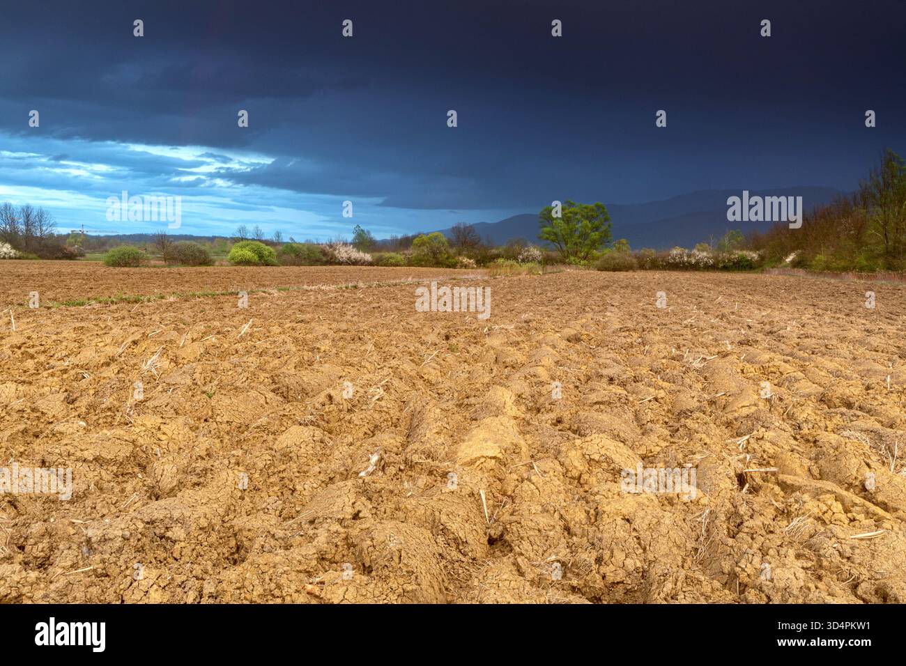 Campo di fango sotto nuvole di tempesta in primavera Foto Stock