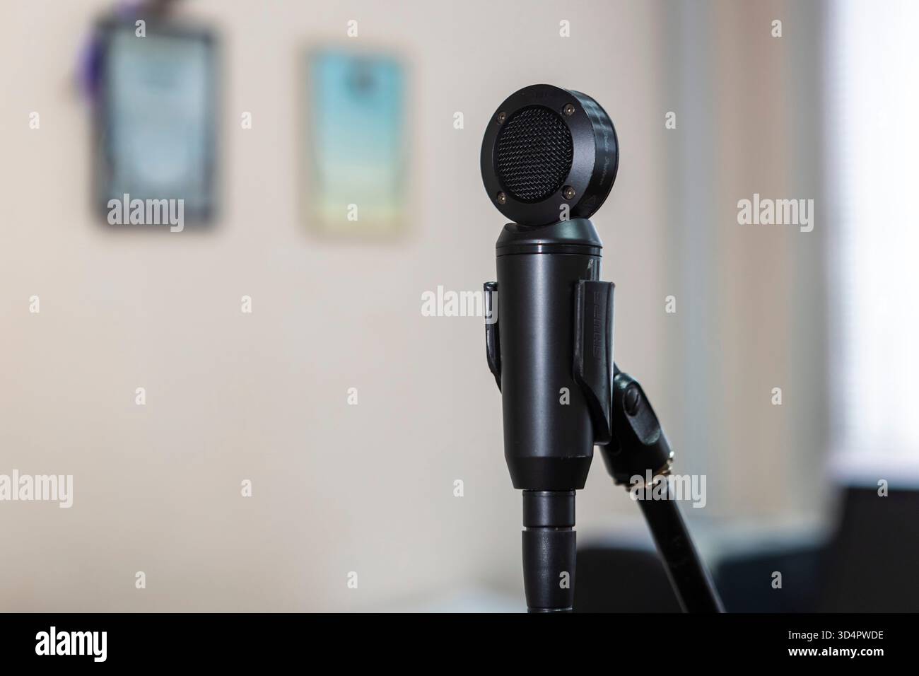 Primo piano di microfoni in uno studio, cattura l'audio con precisione, circondato da cavi e apparecchiature sotto controllo per registrare musica Foto Stock