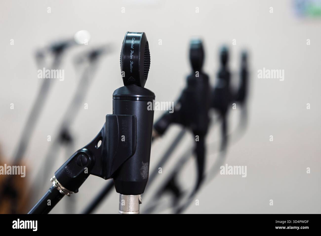 Primo piano di microfoni in uno studio, cattura l'audio con precisione, circondato da cavi e apparecchiature sotto controllo per registrare musica Foto Stock